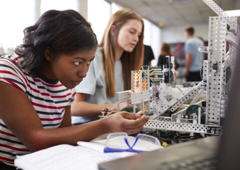 Two Female College Students Building Machine In Science Robotics Or Engineering Class