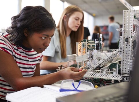 Two Female College Students Building Machine In Science Robotics Or Engineering Class