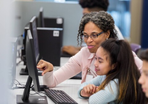 Teacher helps students in computer lab